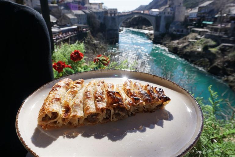Burek proeven, met zicht op de brug van Mostar, Bosnië