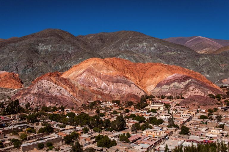 De kleurrijke berg met het dorp in de voorgrond