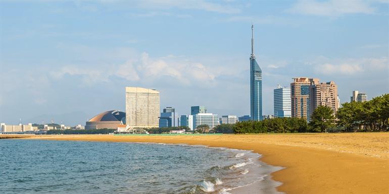 De skyline van Fukuoka vanaf de kust