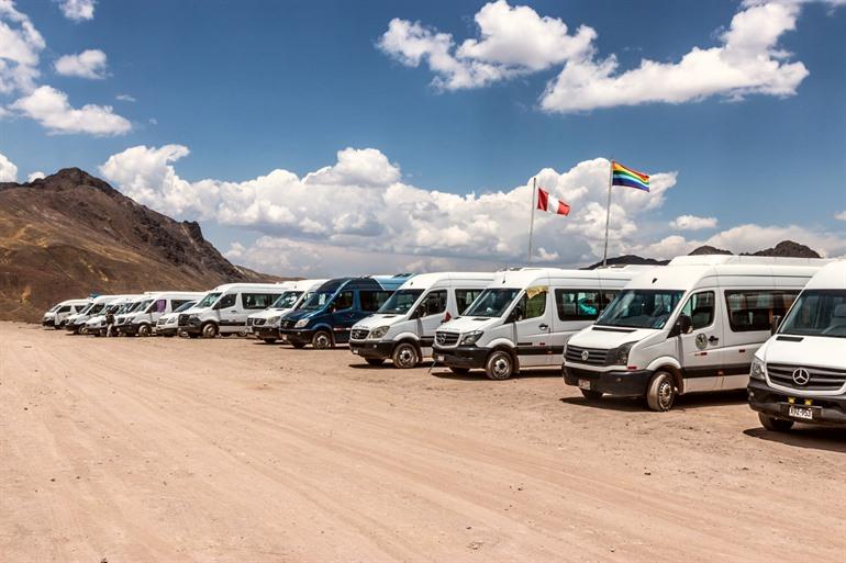 De tourbussen op de parking van Rainbow Mountain