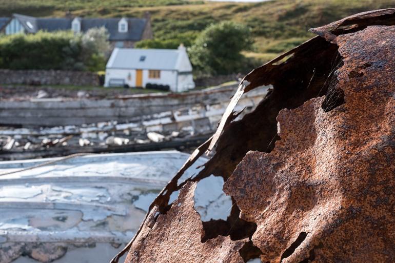 Roestige boei op het strand van Polbain