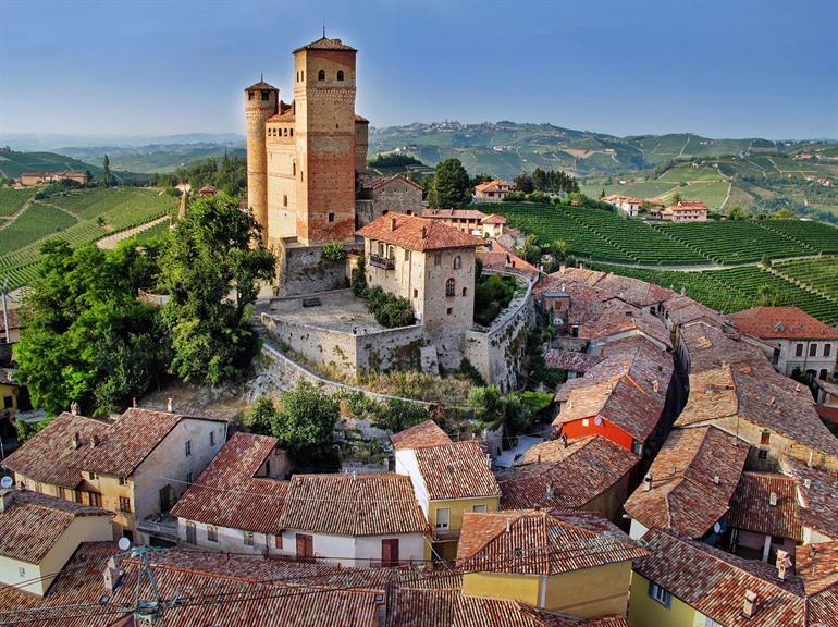 Zicht op het kasteel van Serralunga d'Alba omgeven door smalle straatjes en wijngaarden, Italië